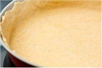 法式鳟鱼西兰花乳蛋饼,将面团从冰箱取出，擀成薄皮，放入圆形的烤盘中。用叉子在面皮上均匀的戳写小孔。再放入冰箱冻15分钟