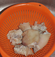 红焖猪蹄,猪蹄清洗干净，锅中放水放葱姜烧开后，放入猪蹄开着盖子煮两分钟，捞出用冷水冲降温，沥干。