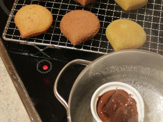 刺猬栗子小蛋糕,栗子迷你蛋糕放涼。 巧克力隔水加热致溶化。 把全部的栗子蛋糕分成两部份，第一份是做成栗子造型：在迷你蛋糕下缘部份涂上巧克力，模拟成栗子壳的样子。