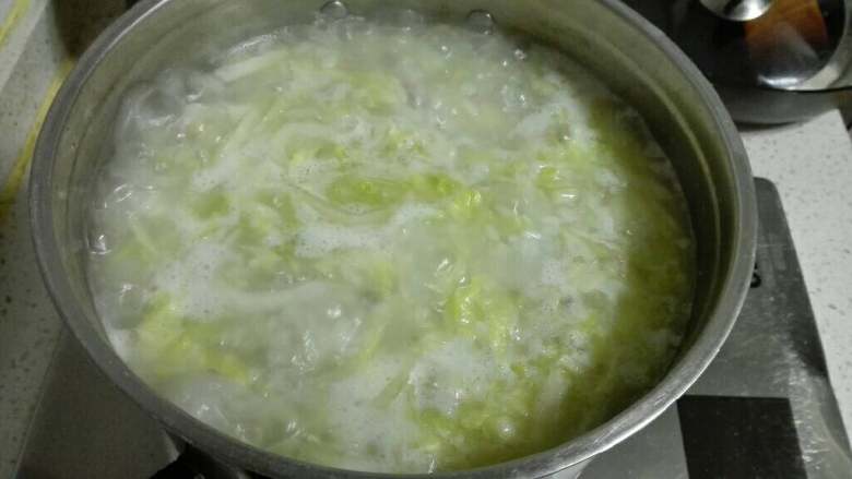 羊肉白菜咸饭,将炒好的白菜肉馅一起倒入煮米的锅中，小火慢慢熬。