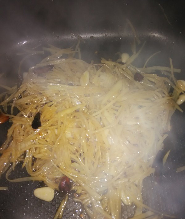 酸辣土豆丝,最后放入大蒜提味适当翻炒，出锅之前放入盐鸡精翻炒片刻即可出锅