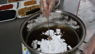 阿胶糕（纯手工制作）,泡制24小时后，将事前打粉完成后的冰糖倒入锅中，搅拌均匀。