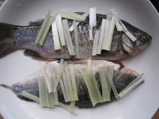 剁椒鲫鱼,腌好的鱼头，冲洗干净，摆盘，放入葱丝，姜丝。