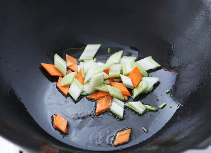 红烧藕丸,锅中少许底油，放入葱花、芹菜、胡萝卜爆香。
