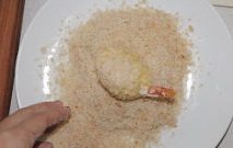 炸虾马铃薯混血可乐饼,捞出后放入面包粉里,尽量多粘一些,同时调整形状