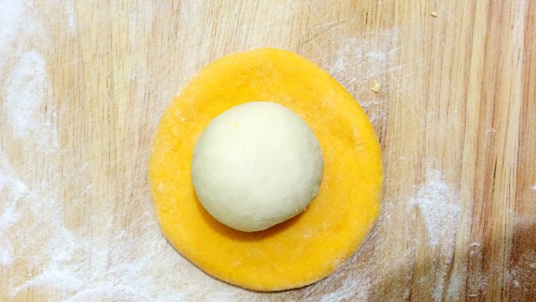 南瓜窝头,发好的面揉成光滑的面团，取黄色的面擀成圆片，白色的面搓成圆形