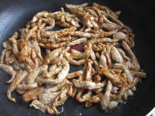 家常鱼香肉丝,下入胡萝卜和木耳丝炒均匀。