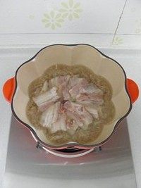 酸菜汆白肉,然后倒入肉汤，将切好的五花肉摆在酸菜上，加盐调味。