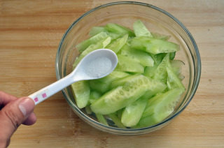 黄瓜汆里脊肉片,把黄瓜片盛到小碗里，撒少许精盐杀水后，控净水备用。
