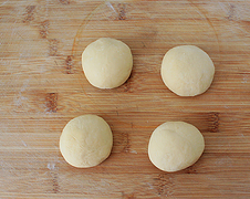 红豆沙面包卷,将发酵好的面团揉匀均分为4份，滚圆，盖上保鲜膜松弛15分钟进行中间发酵。