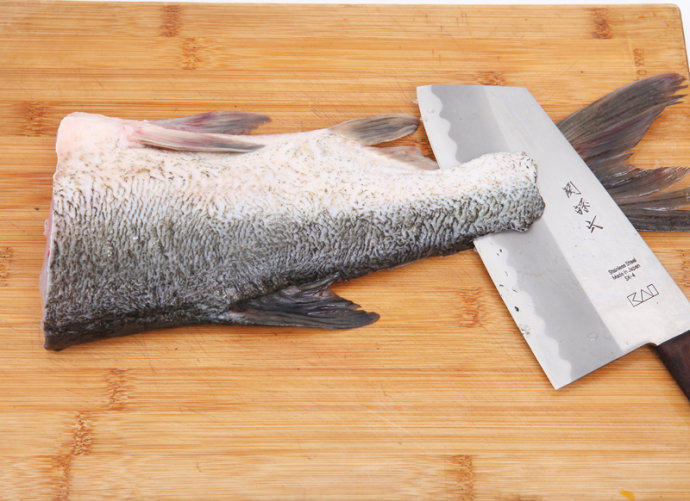 自制鱼丸 ,取有骨的一片鱼，背部朝上，用刀从尾部片去鱼骨。