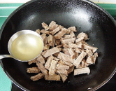 自制咖喱牛肉干,把牛肉条放入炒锅中，加入1大勺煮牛肉的原汤。