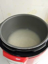 鸡汤菌菇焖饭,大米淘洗干净，放进电饭煲后加水浸泡，水量要比平时焖饭少一点。