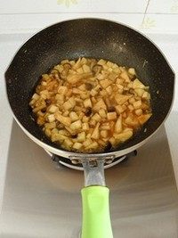 鸡汤菌菇焖饭,倒入2汤匙的浓缩鸡汤，翻炒均匀后中火煮2分钟。