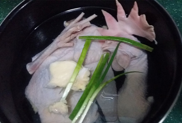 木耳炖鸡汤,将半只老母鸡与香葱一起放入高压锅内胆中，并加入适量清水