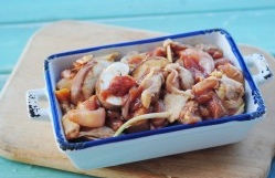 香菇蒸滑鸡,将香菇片和腌好的鸡腿肉拌匀放入碗中。