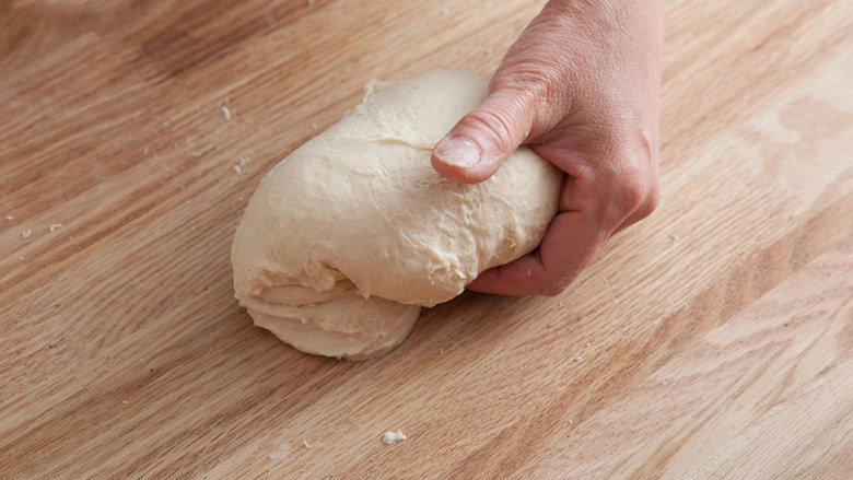 海地白面包,把所有材料一起搅拌均匀，边摔边揉，反复这个动作，大约10分钟。把面团揉成圆形