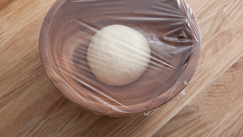 海地白面包,面团封口向下，放入容器中盖上保鲜膜发酵。室温发酵醒发25-35分钟