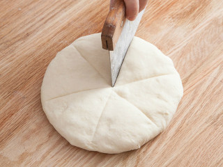 海地白面包,用手指轻压面团确认发酵情况，用拳头向下轻压面团，排除多余空气。将面团分成6等分