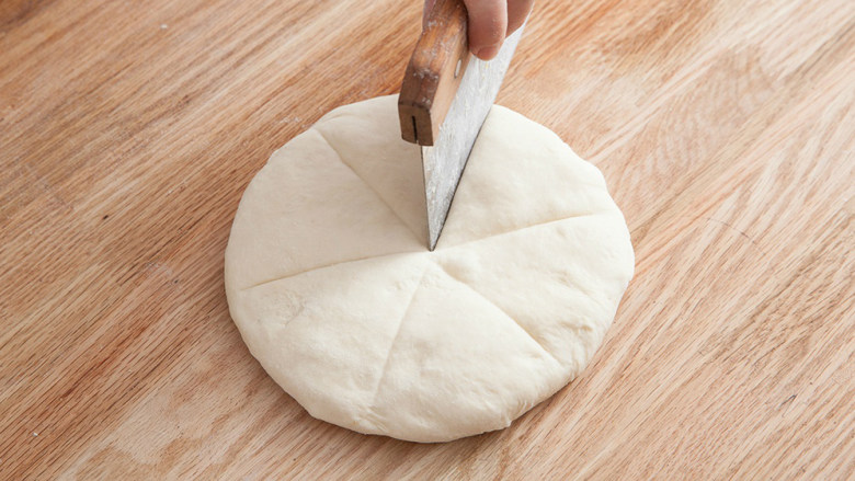 海地白面包,用手指轻压面团确认发酵情况，用拳头向下轻压面团，排除多余空气。将面团分成6等分