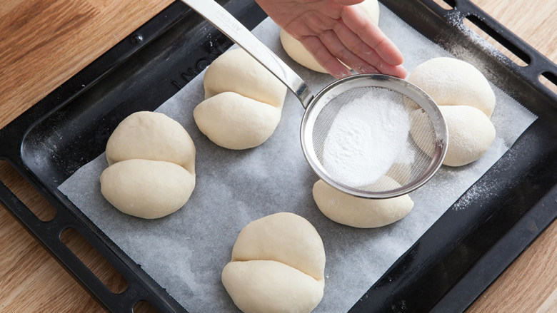 海地白面包,表面撒上过筛米粉。（凹处不要筛粉）烤箱预热180度，烤制11分钟