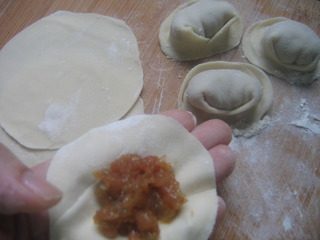 江毛水饺,把馅料放入面皮中，包成馄饨。