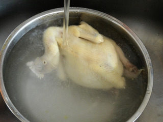 私房白切鸡,将煮好的三黄鸡用凉水冲凉使之迅速冷却。