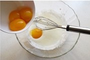 酸奶柠檬中空戚风蛋糕 ,加入15克细砂糖后，蛋黄一颗颗的加入，并用手动打蛋器将其搅打均匀。
