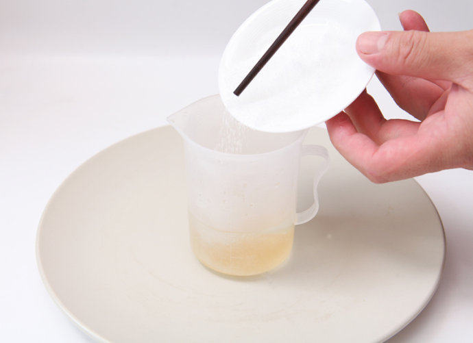 芒果慕斯杯,在量杯中倒入80ml的热水，倒入吉利丁粉10克，搅拌使其溶解。
