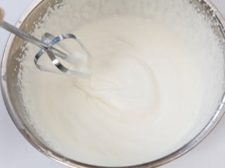 芒果慕斯杯,取另一个干净的碗，倒入100克淡奶油，用电动打蛋器打发至八成有粘稠感。