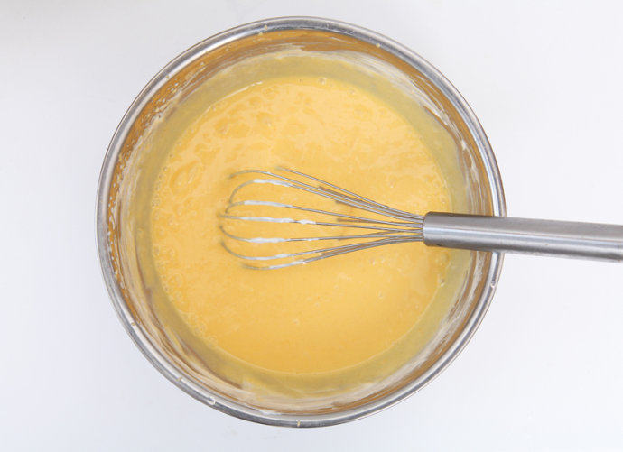 芒果慕斯杯,将打发好的淡奶油与芒果汁搅拌混合均匀。