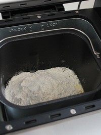 酒渍提子面包,将面包桶放入面包机内并锁定位置。