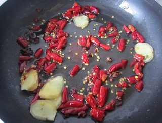 美味的酸菜牛肉,油锅烧热，下入干红椒，生姜片，花椒，大料。