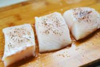 橙香煎鳕鱼,接着洒入黑胡椒粒（比胡椒粉更添香气），也可以放入喜欢的香草腌制10分钟即可。