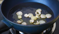 橙香煎鳕鱼,锅中放入2大勺橄榄油，将洋葱片放入炒香后盛盘。