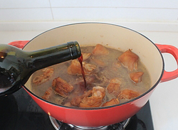 红酒花生烧猪蹄,上色后的猪蹄转至汤锅，调入热水600ml，红酒100ml至汤汁没过猪蹄。