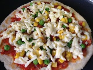彩蔬培根牛肉粒披萨,给饼子抹上披萨酱，堆上素菜，撒上马苏里拉奶酪