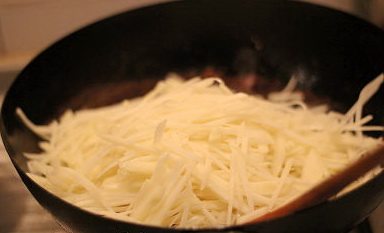 马铃薯欧姆蛋,放入沥干水分的土豆丝混合,炒到透明