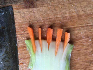 佛手观音莲,煮好的白菜梗三折，再用刀划五下，再将胡萝卜段放入做成佛手