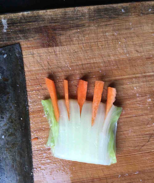佛手观音莲,煮好的白菜梗三折，再用刀划五下，再将胡萝卜段放入做成佛手