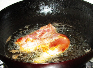 四喜鸭腿,炒锅内油，中火烧至九成热，下入腌制的鸭腿。