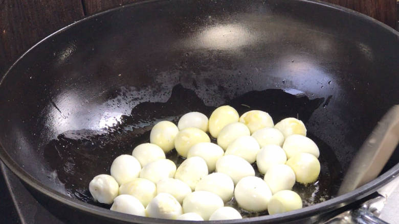 脆皮蛋烧肉,再起锅热油，放入鹌鹑蛋，炸炒至表面焦黄成虎皮状