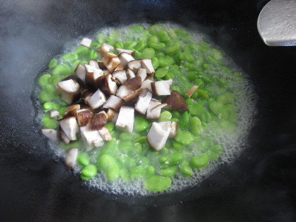 炒蚕豆,水分快收干时加入香菇丁，翻炒，让其水分完全收干就可以起锅了