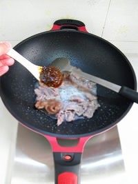 黑椒炒牛肉,待牛肉翻炒至表面变白，放入一汤匙黑椒酱，翻炒均匀。