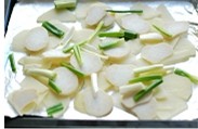 彩椒葱香土豆片,将土豆片和杏鲍菇片放在烤盘上，撒上香葱段。