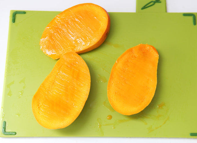 芒果水晶果冻,切好的芒果成三块，两瓣果肉，一瓣果核。