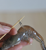 龙井茶香虾,用牙签从虾头往下数第二节处戳进去挑出虾场（如果挑断就再往下移一节挑）。