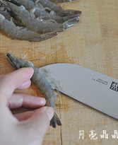龙井茶香虾,用食指和拇指固定住虾头和虾尾，无名指往前抵住虾的肚子，用刀在虾肚子上开一刀。