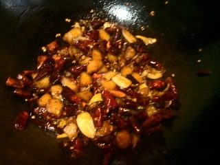 辣子鸡丁,沿锅边到入酱汁翻匀，关火后调入味精起锅。