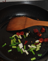 潮式豉椒炒双丸,锅中放两小勺油烧热，下葱段和干辣椒段煸香，再放一勺老干妈豆豉酱炒出香味。